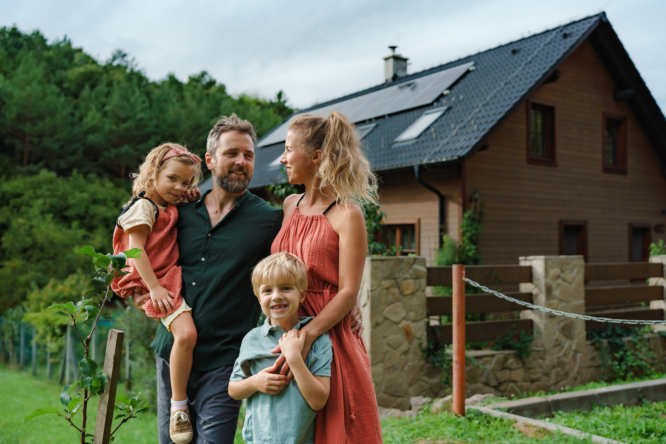 Familie vor ihrem Haus mit Solaranlage
